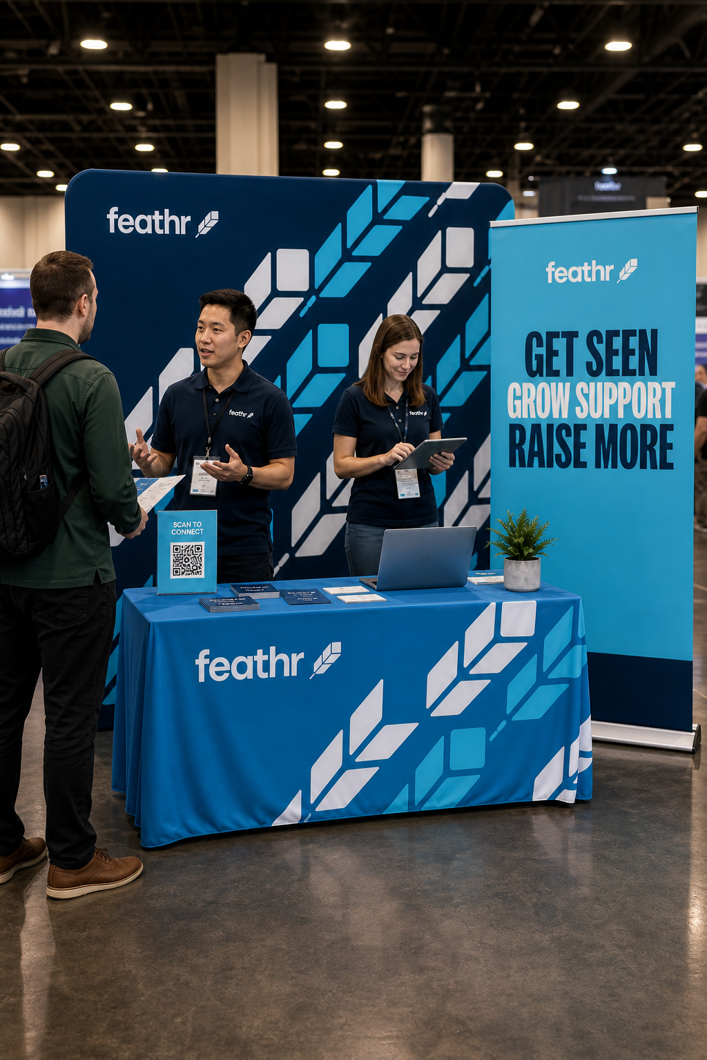 Feathr tradeshow booth showcasing blue and teal graphics, a matching table throw, and active banners on the show floor.